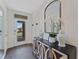 Inviting entryway features a decorative console table with an arched mirror and views of the front yard at 5852 Galloping Dr, Apopka, FL 32712