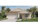 Charming single-story home featuring a 1-car garage, tan siding, and a well-maintained lawn at 5852 Galloping Dr, Apopka, FL 32712