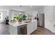 Bright, modern kitchen with stainless steel appliances, a center island, and an adjacent dining area at 5852 Galloping Dr, Apopka, FL 32712