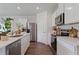 Well-equipped kitchen featuring white cabinetry, stainless steel appliances, and wood-look floors at 5852 Galloping Dr, Apopka, FL 32712