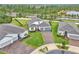 Aerial view of a home with a brick driveway, well-kept lawn, and surrounded by lush landscaping and other homes at 6105 Citrus Grove Ct, St Cloud, FL 34771