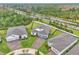 Aerial view of a home with a brick driveway, well-kept lawn, and surrounded by lush landscaping and other homes at 6105 Citrus Grove Ct, St Cloud, FL 34771