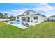 Backyard with a pool, patio, lounge seating, a built-in outdoor kitchen, lawn area, and white fence at 6105 Citrus Grove Ct, St Cloud, FL 34771