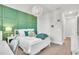 Bright bedroom with a decorative green accent wall and overhead lighting fixture at 6105 Citrus Grove Ct, St Cloud, FL 34771
