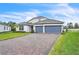 Charming two-story home with a brick driveway, manicured lawn, and gray paint at 6105 Citrus Grove Ct, St Cloud, FL 34771