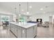 Open-concept kitchen with gray cabinets, quartz countertops, stainless appliances, and seamless flow to the living area at 6105 Citrus Grove Ct, St Cloud, FL 34771
