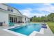 Backyard with a pool, patio, lounge seating, lawn area, black metal fence and white privacy fence at 6105 Citrus Grove Ct, St Cloud, FL 34771