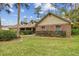 Inviting home featuring a brick accent wall, lush landscaping, and a well-maintained lawn at 743 Riverbend Blvd, Longwood, FL 32779