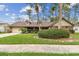 Charming single-story home featuring a well-manicured front yard, mature trees, and an attached two-car garage at 743 Riverbend Blvd, Longwood, FL 32779