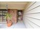 Covered front porch with brick accents, a storm door, and a charming plant creating a warm welcome at 743 Riverbend Blvd, Longwood, FL 32779