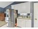 Bright kitchen features stainless steel refrigerator and white cabinets at 743 Riverbend Blvd, Longwood, FL 32779