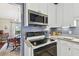 Well-lit kitchen boasts white cabinetry, stainless steel microwave, and granite countertops at 743 Riverbend Blvd, Longwood, FL 32779