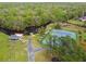 Aerial view of well-maintained tennis courts next to a lake and boat storage at 743 Riverbend Blvd, Longwood, FL 32779