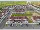 Extensive aerial view of a townhome community with ample parking, green spaces, and surrounding trees at 7558 Sunflower Cir, Kissimmee, FL 34747