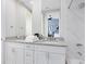 A bright bathroom with double vanity, granite countertop, and tiled shower/bath at 7558 Sunflower Cir, Kissimmee, FL 34747