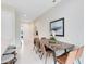 Dining area featuring a stylish wooden table and chairs, complemented by sleek tile flooring and modern decor at 7558 Sunflower Cir, Kissimmee, FL 34747