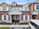 Charming townhouse exterior featuring red and tan siding, white trim, and well-maintained landscaping at 7558 Sunflower Cir, Kissimmee, FL 34747