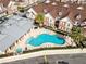 Aerial view of community pool with lounge chairs, clubhouse, and condo buildings at 7558 Sunflower Cir, Kissimmee, FL 34747