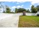 Spacious backyard featuring a white fence, lush grass and a mature tree stump at 7633 Marietta St, Orlando, FL 32807
