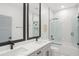 Modern bathroom with double vanity, sleek fixtures, and luxurious marble-tiled shower and walls at 7633 Marietta St, Orlando, FL 32807