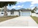 Charming home with a well-manicured lawn, blue garage door, and ample driveway space at 7633 Marietta St, Orlando, FL 32807