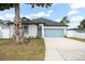 Charming home with a well-manicured lawn, blue garage door, and ample driveway space at 7633 Marietta St, Orlando, FL 32807