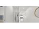 Bright hallway featuring white walls, recessed lighting, and sleek tile flooring at 7633 Marietta St, Orlando, FL 32807