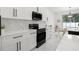 Modern kitchen with white cabinets, stainless steel appliances, and a breakfast nook overlooking the yard at 7633 Marietta St, Orlando, FL 32807
