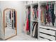 Well-organized walk-in closet featuring shelving, hanging rods, and a full-length mirror at 7633 Marietta St, Orlando, FL 32807