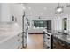 Open concept kitchen and living room with white cabinetry, stainless appliances, and black framed windows at 806 Edgewater Dr, Orlando, FL 32804