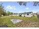 A sprawling backyard showcases a mix of grass, a concrete slab, shade trees, and ample space for various outdoor activities at 858 Darwin Dr, Altamonte Springs, FL 32701