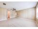 Large, bright living room features light paneling, tile floors, a ceiling fan, and a connecting door to the utility room at 858 Darwin Dr, Altamonte Springs, FL 32701
