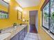 Bright bathroom featuring a double sink vanity, granite countertop, and a view to the outdoors at 872 Huckleberry Ln, Winter Springs, FL 32708