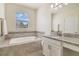 Bright bathroom featuring a soaking tub, granite vanity, and tile accents, illuminated by natural light at 10012 Lovegrass Ln, Orlando, FL 32832