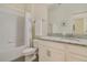 Well-lit bathroom features a tub and shower with a granite countertop and white cabinets at 10012 Lovegrass Ln, Orlando, FL 32832