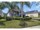 Single-Gathering home featuring a well-maintained lawn, brick-paved driveway, and an attached two-car garage at 10012 Lovegrass Ln, Orlando, FL 32832