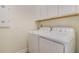 Functional laundry room featuring a white washer and dryer set, and ample overhead cabinet space at 10012 Lovegrass Ln, Orlando, FL 32832