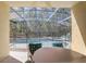 Relaxing view of the screened-in swimming pool and jacuzzi surrounded by lush trees at 1025 Sandy Ridge Dr, Davenport, FL 33896