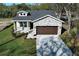 An aerial view shows a home with a stone facade, driveway pavers, and lush lawn at 1038 Dennis Ave, Orlando, FL 32807