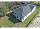 Aerial view of home with a patio, well-manicured lawn, dark roof, and bright exterior at 1038 Dennis Ave, Orlando, FL 32807