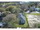 An aerial view of a neighborhood home with well-kept lawn near surrounding trees and buildings at 1038 Dennis Ave, Orlando, FL 32807