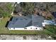 Aerial view of a residential home with a dark roof, white siding, and a well-maintained lawn at 1038 Dennis Ave, Orlando, FL 32807