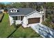 Charming home featuring stone accents, a paved driveway, manicured lawn, and a dormer window at 1038 Dennis Ave, Orlando, FL 32807