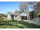 Attractive home featuring stone facade, a well-manicured lawn, and a paved driveway leading to the garage at 1038 Dennis Ave, Orlando, FL 32807