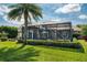 Exterior view of a screened-in patio, beautiful lush backyard, and mature trees at 11234 Willow Gardens Dr, Windermere, FL 34786