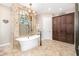 Luxurious primary bathroom featuring a freestanding tub, walk-in shower, tile floors and elegant lighting at 11234 Willow Gardens Dr, Windermere, FL 34786