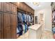 Spacious walk-in closet featuring custom shelving, cabinetry, and a center island for organization at 11234 Willow Gardens Dr, Windermere, FL 34786