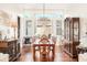 Formal dining room with a decorative chandelier, dark hardwood floors, large windows, and traditional furnishings at 11234 Willow Gardens Dr, Windermere, FL 34786