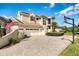 View of the side of a two-story home with a three-car garage, brick driveway, and a basketball hoop at 11234 Willow Gardens Dr, Windermere, FL 34786