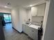 Functional laundry room with modern washer and dryer, cabinet storage, and convenient access to the backyard at 1218 Depugh St, Altamonte Springs, FL 32701